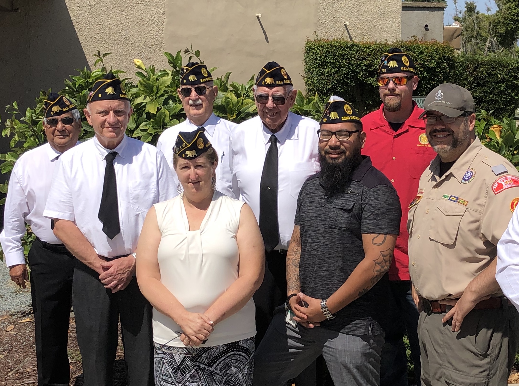 American Legion Post 6 members in formal uniform with San Diego caps posing with community members