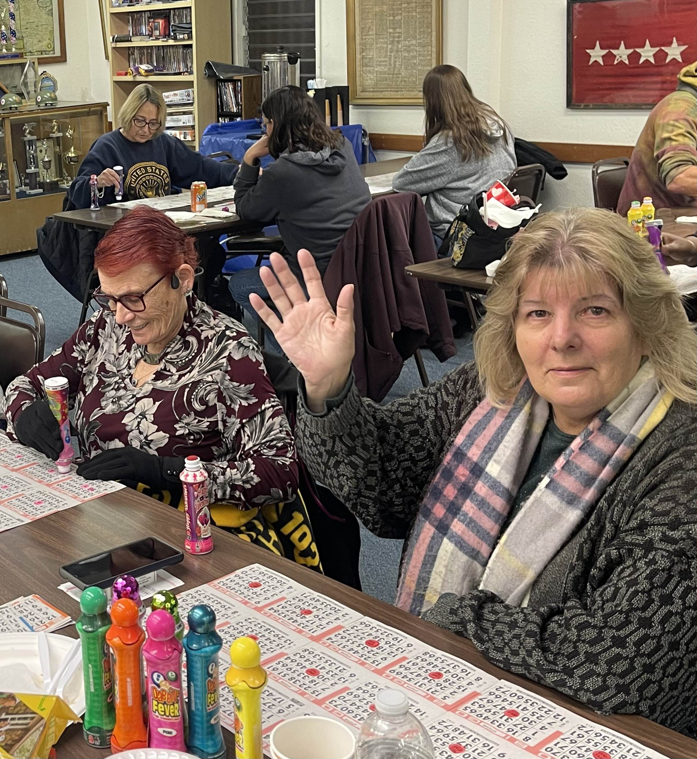 Veterans and community members enjoying bingo night with colorful daubers and bingo cards