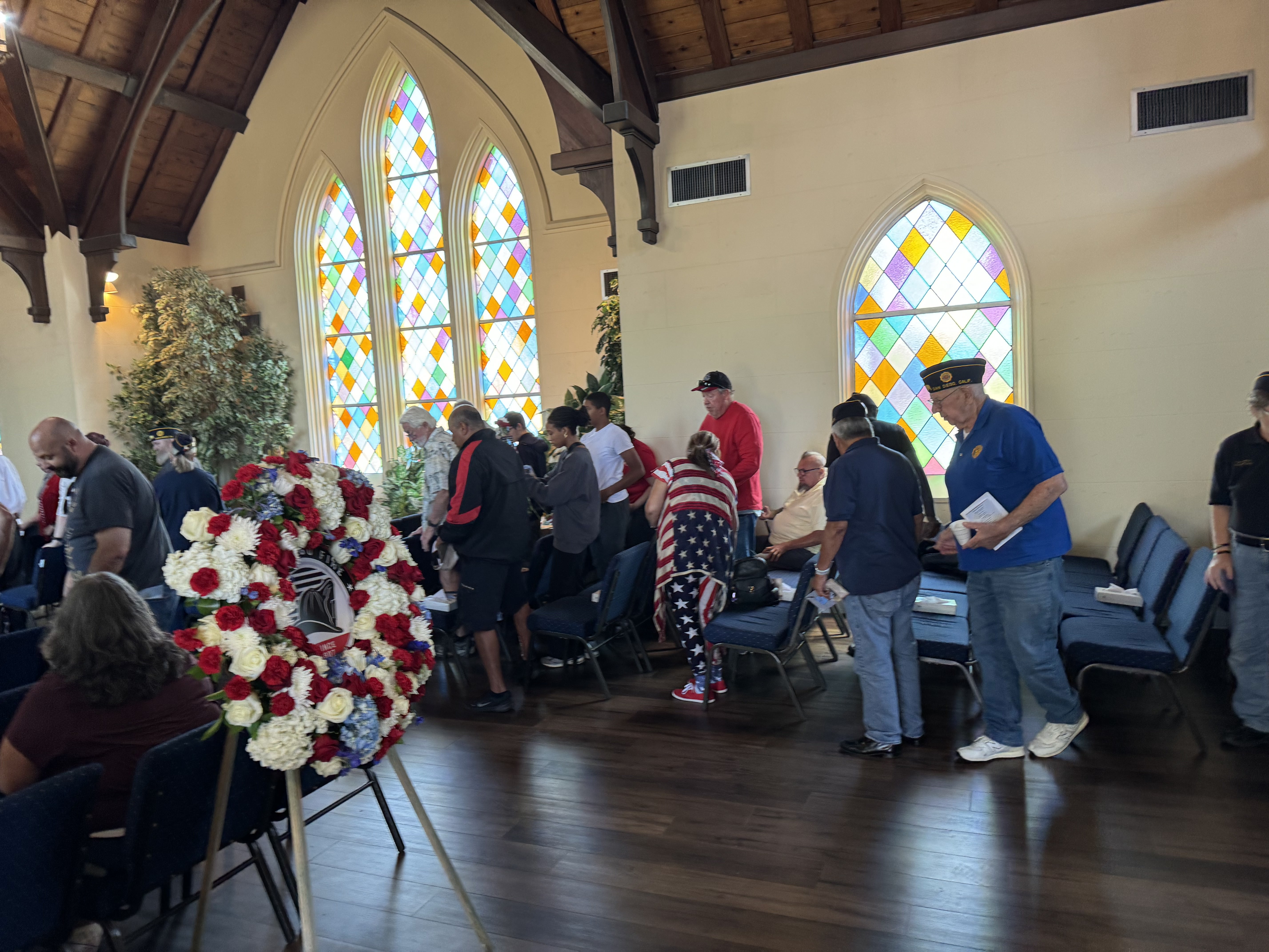 Memorial Day service in chapel with patriotic wreath and veterans gathering for ceremony